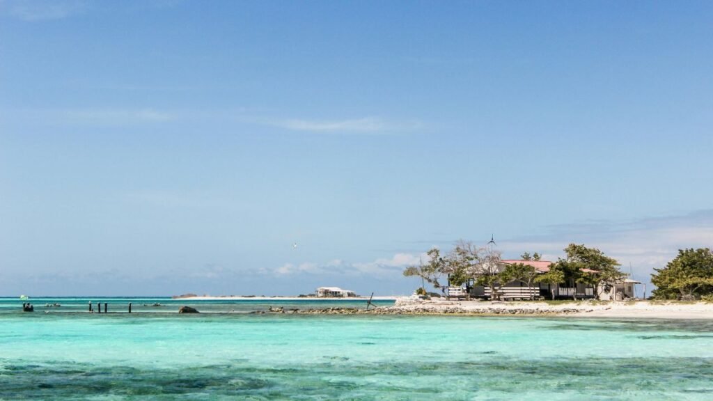 Turquoise waters and white sand beach with a small coastal house on Los Roques archipelago, Venezuela