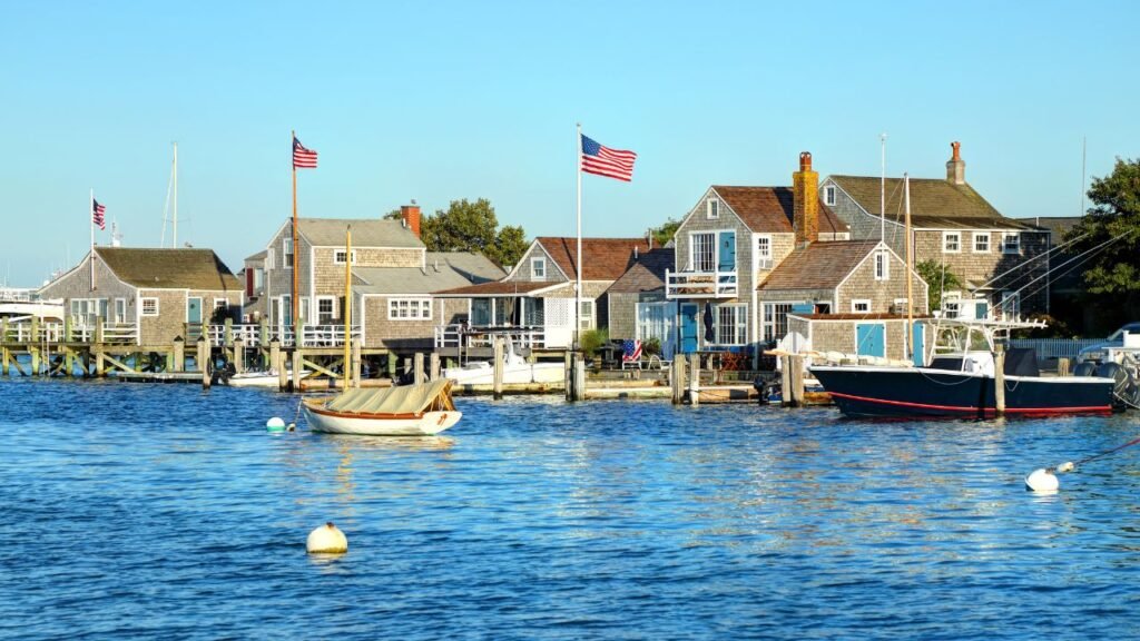 Traditional gray shingle-style boathouses on a wooden pier over water in Nantucket, Massachusetts