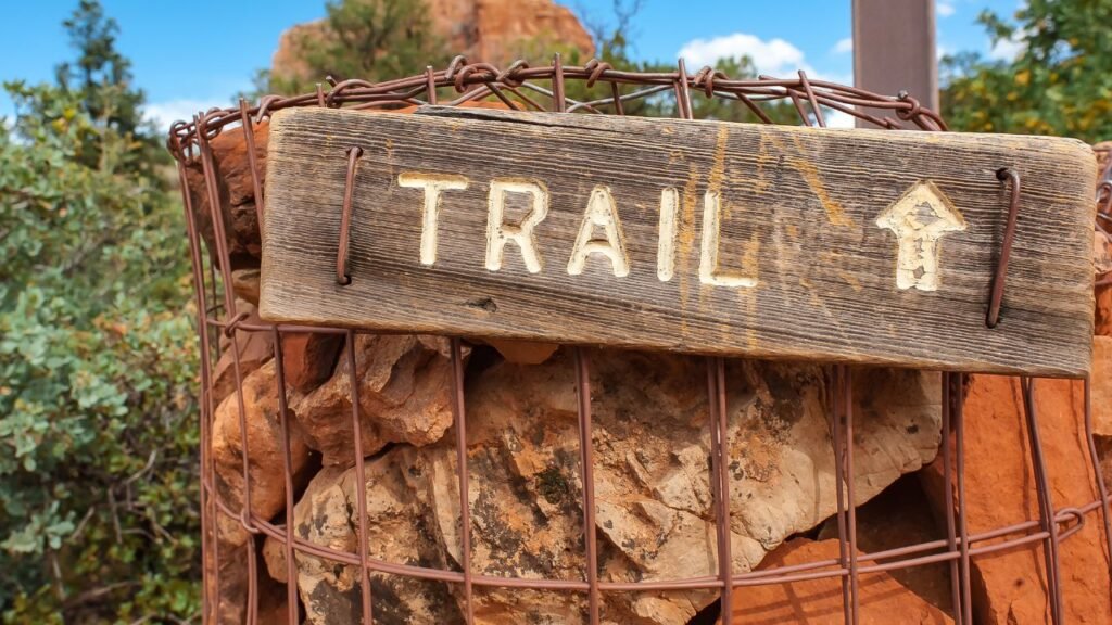 Wooden trail marker sign on a rock cairn along a hiking trail in Sedona, Arizona