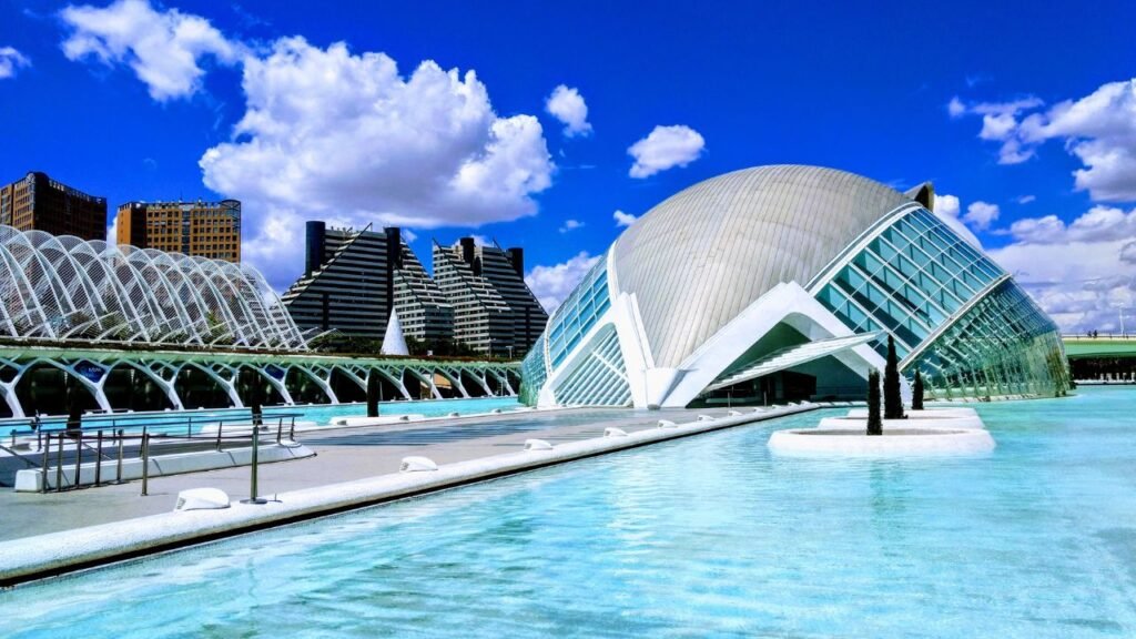 L'Hemisfèric eye-shaped building and Palau de les Arts Reina Sofía reflected in the water at City of Arts and Sciences, Valencia