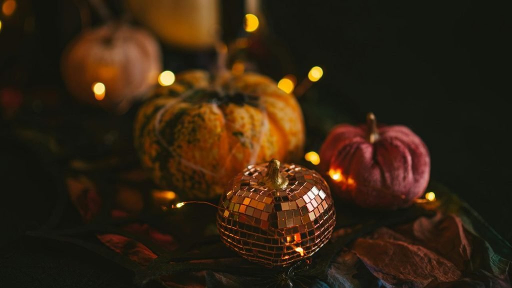 Decorative mini pumpkins including a sparkly disco ball pumpkin and velvet pumpkin lit by string lights