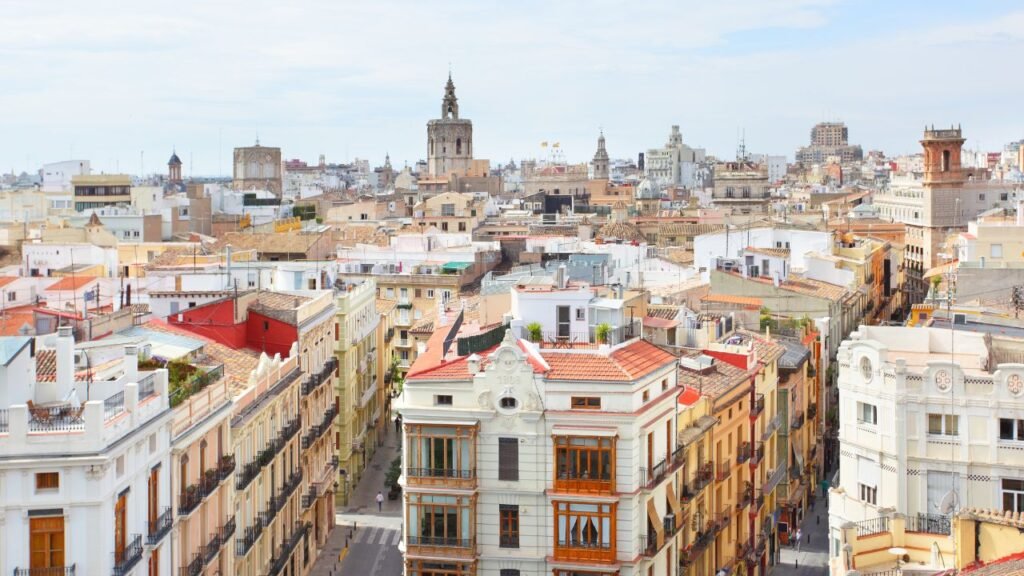Rooftop panorama of Valencia's old town with the cathedral's Micalet tower rising above terracotta rooftops