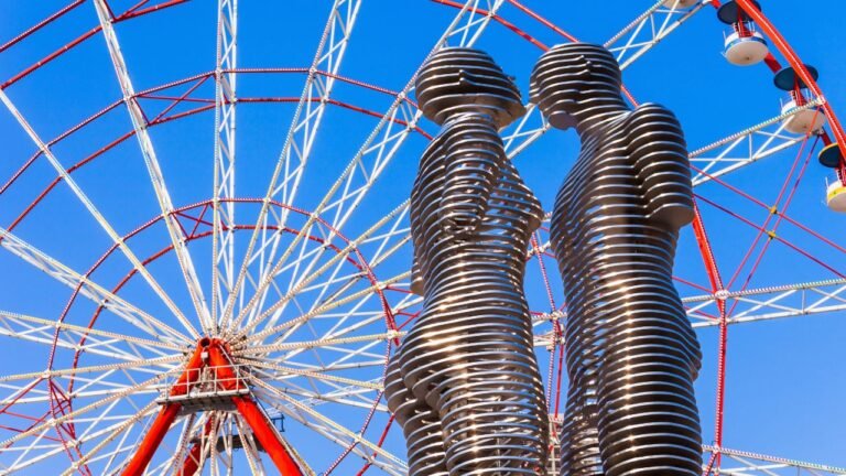 Ali and Nino moving statue with Ferris wheel in the background at Batumi Boulevard, Georgia