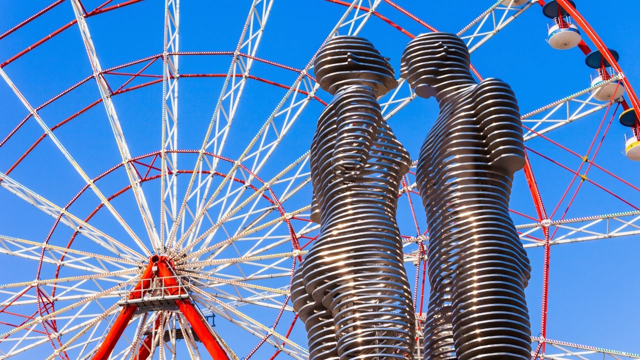 Ali and Nino moving statue with Ferris wheel in the background at Batumi Boulevard, Georgia