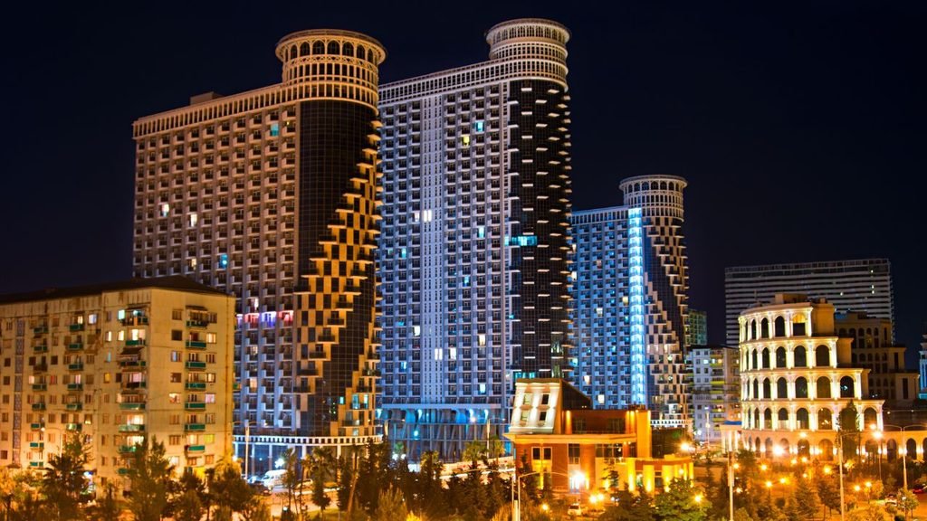 Illuminated modern hotel towers and buildings in Batumi at night