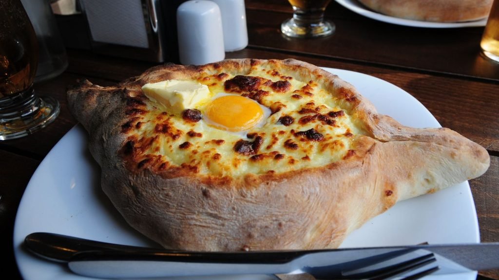 Traditional Adjarian khachapuri boat-shaped bread with cheese, butter, and egg in Batumi